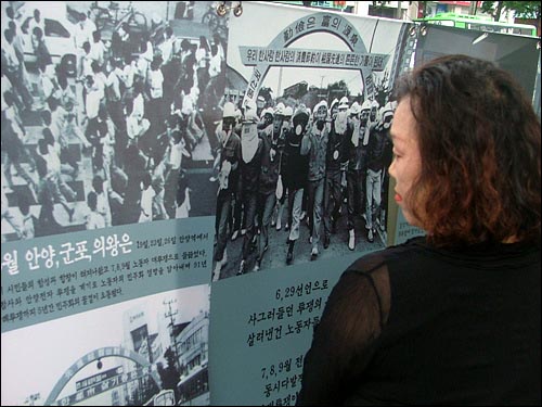 기념식장에서 사진을 보고 있는 시민 